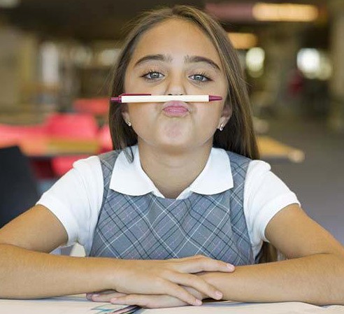 une petit fille tient son crayon