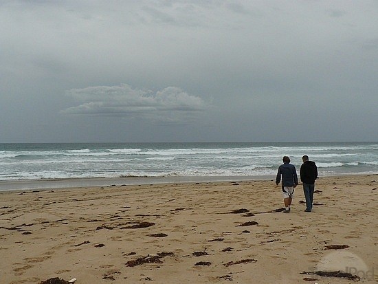 Plage de Sorrento Back avec un ciel couvert et 2 personnes marchant dans le sable