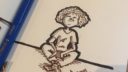 Un crayon bleu dessine une figure féminine nue sur un papier blanc