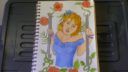 Cahier de dessin avec couverture illustrée et crayon noir, dans le cadre d'Apprendre à Dessiner (AAD)