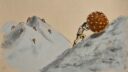 Un homme pousse une grande boule sur une pente montagneuse